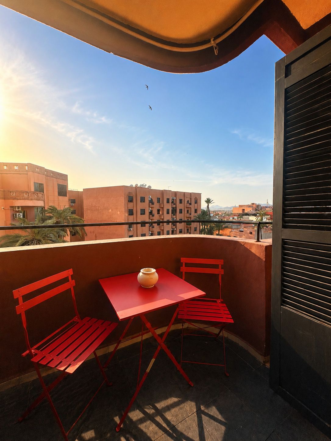 Balcon avec table bistrot rouge en plein jour